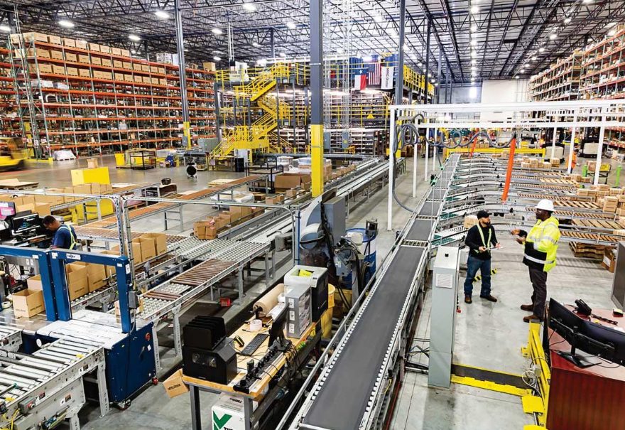 3cxCloud.LT ALERT – logistika: sandėlio konvejerio linija, lentynos su padėklais ir darbuotojai